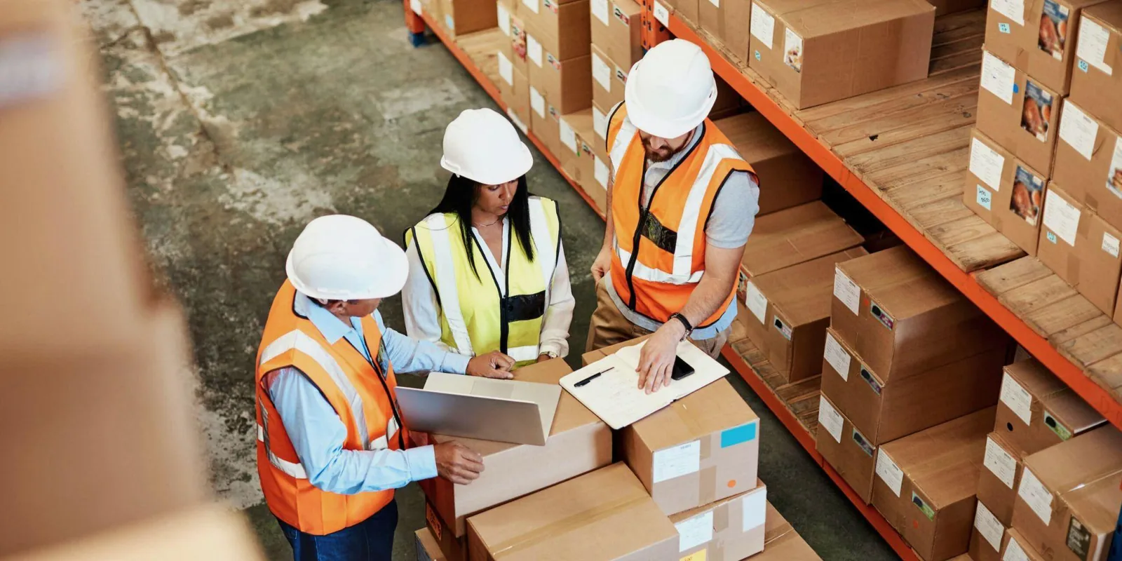 Warehouse team reviewing an order over packed boxes — where brake drum lead time quietly gets lost
